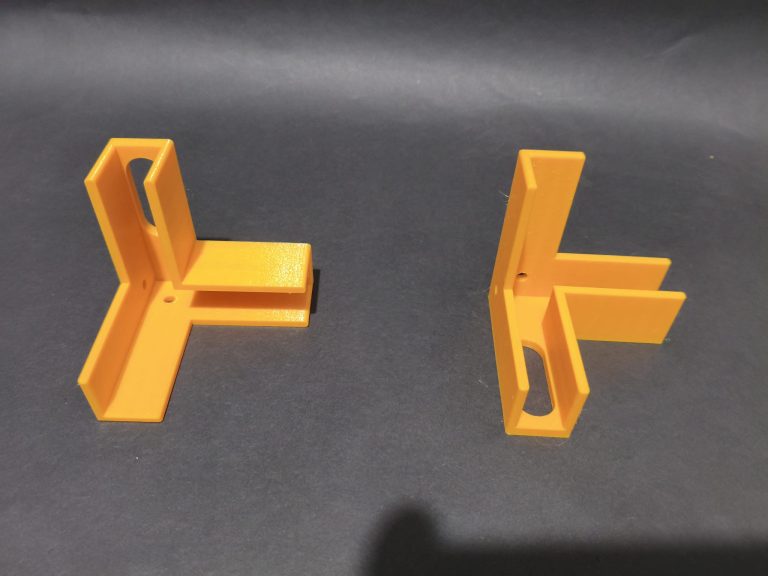 Żółte kąty meblowe z rowkami nasuwanymi na krawędzie płyty, wydruk 3D z PETG