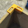 Żółte kąty meblowe z rowkami nasuwanymi na krawędzie płyty, wydruk 3D z PETG