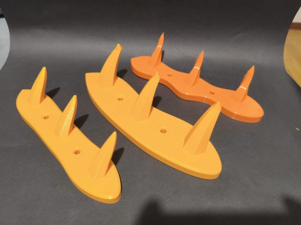Trzy żółte i pomarańczowe wieszaki ścienne z kanciastymi haczykami, wydruk 3D z PETG