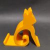 Żółta podstawka pod telefon w kształcie sylwetki siedzącego kota, wydruk 3D z PETG Żółta podstawka pod telefon w kształcie sylwetki siedzącego kota, wydruk 3D z PETG