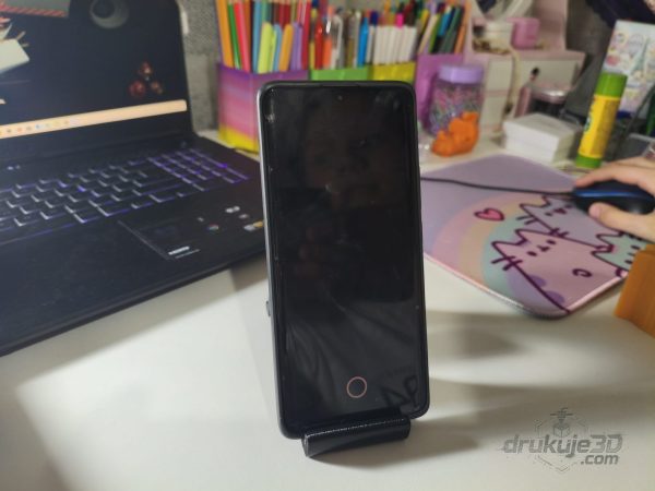 Czarny stojak na telefon w kształcie siedzącego tygrysa z ogonem zwiniętym w spiralę, wydruk 3D