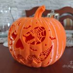 Pomarańczowa dynia z druku 3D o szerokości 24 cm, z ażurową twarzą wypełnioną pajęczynami, nietoperzami i gwiazdkami