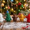Wizualizacja kompletu pięciu figurek świątecznych z druku 3D po 8 cm – bałwan, skrzat, renifer, aniołek i Mikołaj w kolorach do wyboru, na tle choinki